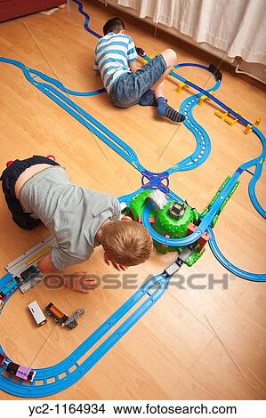 Picture - A photo of two boys 6 & 10 playing with a TOMY Thomas the tank engine train set in the Uk. Fotosearch