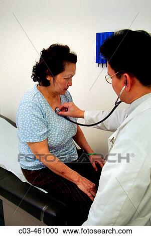 A physician examines a middle-aged woman at a neighborhood health clinic in a Vietnamese section of Fullerton, California View Large Photo Image Stock Image - A physician examines a middle-aged woman at a neighborhood health clinic in a Vietnamese section of Fullerton, California. Fotosearch