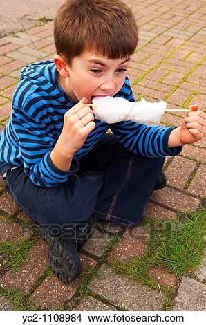 A picture of a 10 year old boy eating candy floss in the Uk View Large Photo Image Picture - A picture of a 10 year old boy eating candy floss in the Uk. Fotosearch