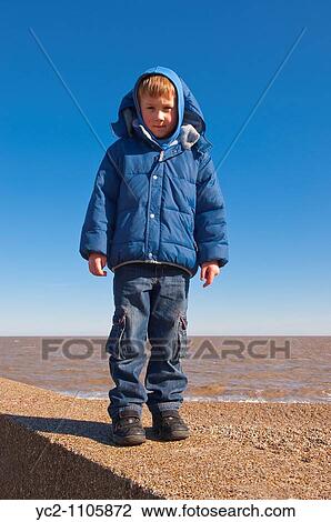 A picture of a 6 year old boy standing on the sea wall on a uk beach View Large Photo Image Stock Image - A picture of a 6 year old boy standing on the sea wall on a uk beach. Fotosearch