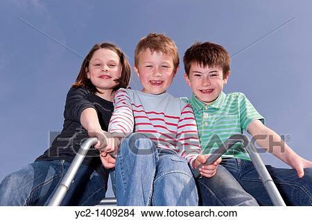 A picture of a girl and two boys outdoors on a climbing frame in the Uk View Large Photo Image Picture - A picture of a girl and two boys outdoors on a climbing frame in the Uk. Fotosearch