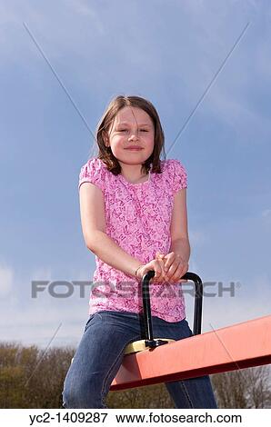 A picture of a nine year old girl outdoors on a seesaw in the Uk View Large Photo Image Stock Photo - A picture of a nine year old girl outdoors on a seesaw in the Uk. Fotosearch