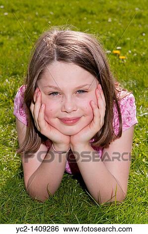 A picture of a nine year old girl outdoors laying on the grass in the Uk View Large Photo Image Stock Photograph - A picture of a nine year old girl outdoors laying on the grass in the Uk. Fotosearch
