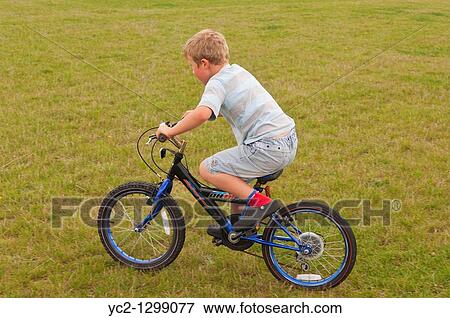 A picture of a seven year old boy riding a bike in the Uk View Large Photo Image Stock Photo - A picture of a seven year old boy riding a bike in the Uk. Fotosearch