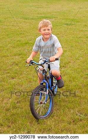 A picture of a seven year old boy riding a bike in the Uk View Large Photo Image Stock Photo - A picture of a seven year old boy riding a bike in the Uk. Fotosearch