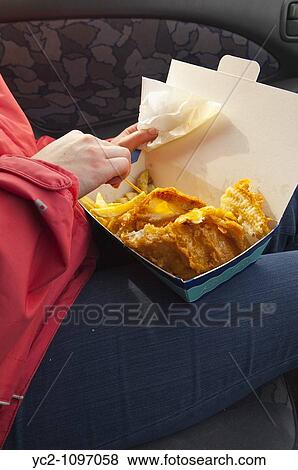 A picture of a woman eating fish & chips in a car in the Uk View Large Photo Image Stock Photo - A picture of a woman eating fish & chips in a car in the Uk. Fotosearch