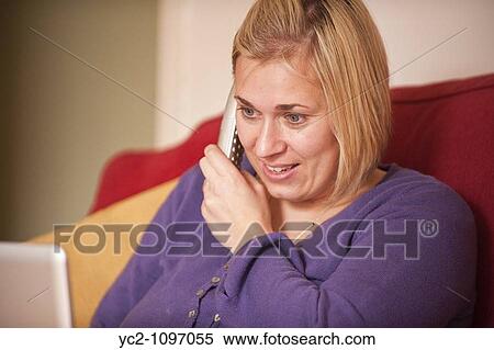 A picture of a woman in her thirties talking on the phone and on a laptop computer in the Uk View Large Photo Image Stock Photography - A picture of a woman in her thirties talking on the phone and on a laptop computer in the Uk. Fotosearch
