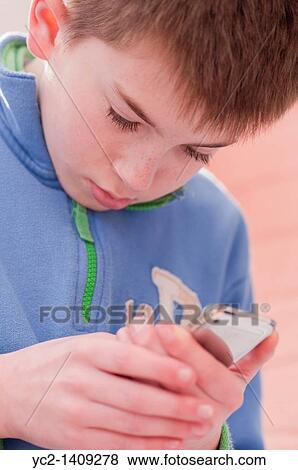 A picture of an eleven year old boy using his Ipod Touch indoors View Large Photo Image Stock Photo - A picture of an eleven year old boy using his Ipod Touch indoors. Fotosearch