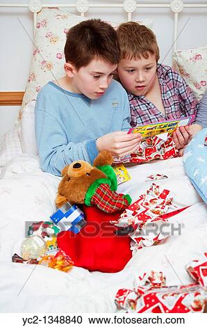 A picture of two boys 11 and 7 opening christmas presents in bed from their stockings in the Uk View Large Photo Image Stock Image - A picture of two boys 11 and 7 opening christmas presents in bed from their stockings in the Uk. Fotosearch