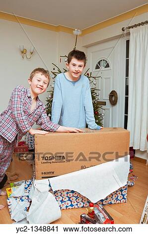 A picture of two boys 11 and 7 opening christmas presents under the tree in the Uk View Large Photo Image Stock Image - A picture of two boys 11 and 7 opening christmas presents under the tree in the Uk. Fotosearch