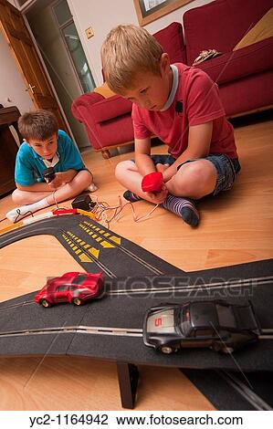 A picture of two boys 6 & 10 playing with a Hornby Scalextric racing car set game in the Uk View Large Photo Image Stock Image - A picture of two boys 6 & 10 playing with a Hornby Scalextric racing car set game in the Uk. Fotosearch