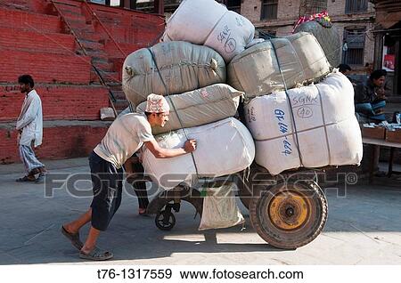 Stock Photo - a porter and his load in Durbar Square in Kathmandu, Nepal. Fotosearch