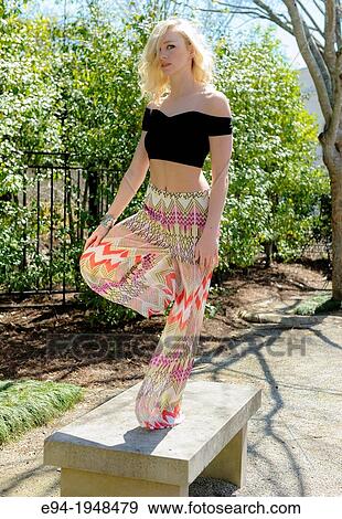 Stock Photo - A portrait of 23 year old blond woman in casual clothing in a garden setting.. Fotosearch