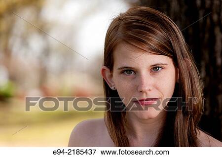 A portrait of a 22 year old brunette woman looking directly at the camera, outdoors. View Large Photo Image Stock Photo - A portrait of a 22 year old brunette woman looking directly at the camera, outdoors.. Fotosearch