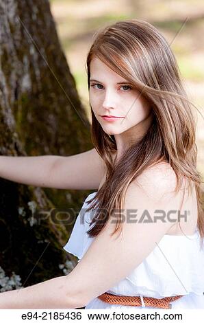 A portrait of a 22 year old brunette woman looking directly at the camera, outdoors. View Large Photo Image Stock Photograph - A portrait of a 22 year old brunette woman looking directly at the camera, outdoors.. Fotosearch