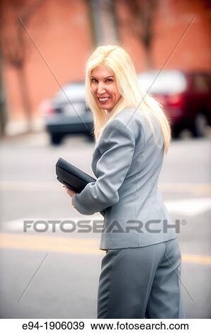 A portrait of a 48 year old blond woman in a business suit in an urban setting looking over her shoulder View Large Photo Image Stock Photo - A portrait of a 48 year old blond woman in a business suit in an urban setting looking over her shoulder. Fotosearch