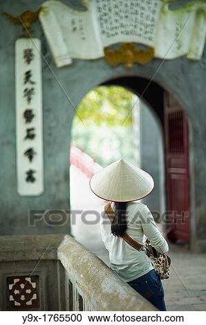 A portrait of a Vietnamese woman wearing a n? n lB or a traditional Vietnamese straw hat contrasted with modern clothes View Large Photo Image Stock Image - A portrait of a Vietnamese woman wearing a n? n lB or a traditional Vietnamese straw hat contrasted with modern clothes. Fotosearch