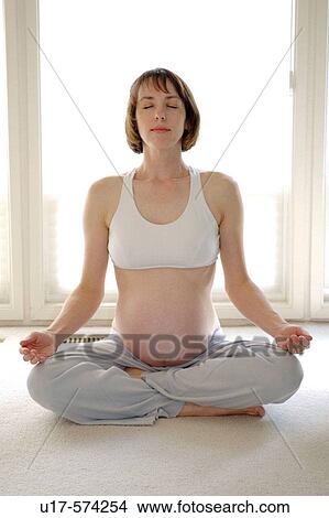 Picture - A pregnant woman in a yoga pose.. Fotosearch