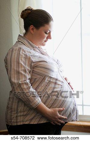 Stock Image - A pregnant young caucasian woman near the end of her third trimester. Fotosearch