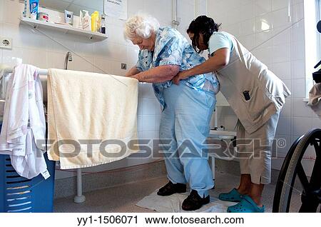 A professional nurse of a Rotterdam nursing home helping an elderly inhabitant getting dressed. View Large Photo Image Stock Image - A professional nurse of a Rotterdam nursing home helping an elderly inhabitant getting dressed.. Fotosearch