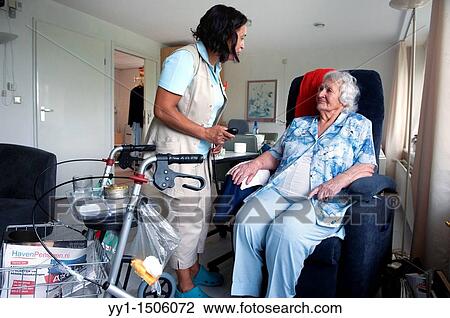 A professional nurse of a Rotterdam nursing home helping an elderly inhabitant with the controls of her chair. View Large Photo Image Stock Image - A professional nurse of a Rotterdam nursing home helping an elderly inhabitant with the controls of her chair.. Fotosearch