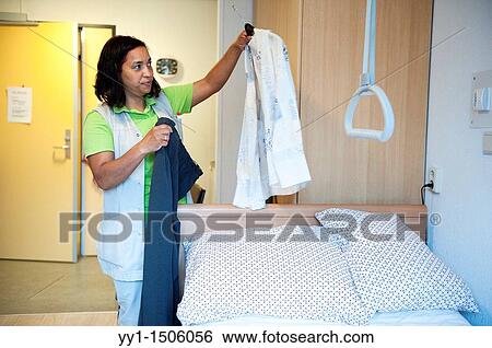 A professional nurse of a Rotterdam nursing home choosing a new set of clothes for an elderly inhabitant. View Large Photo Image Stock Photograph - A professional nurse of a Rotterdam nursing home choosing a new set of clothes for an elderly inhabitant.. Fotosearch