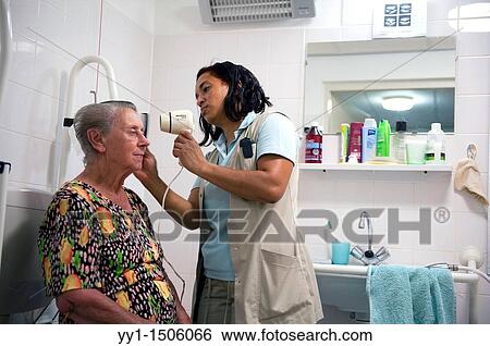 A professional nurse of a Rotterdam nursing home helping an elderly inhabitant getting dressed. View Large Photo Image Stock Photograph - A professional nurse of a Rotterdam nursing home helping an elderly inhabitant getting dressed.. Fotosearch