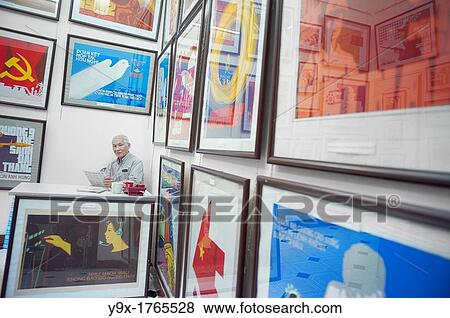 A propaganda poster shop in Vietnam with a man sitting behind a desk View Large Photo Image Stock Photo - A propaganda poster shop in Vietnam with a man sitting behind a desk. Fotosearch
