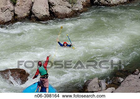 A rafter rescues a man from the rapids while rafting on the Truckee River in California. USA View Large Photo Image Picture - A rafter rescues a man from the rapids while rafting on the Truckee River in California. USA. Fotosearch