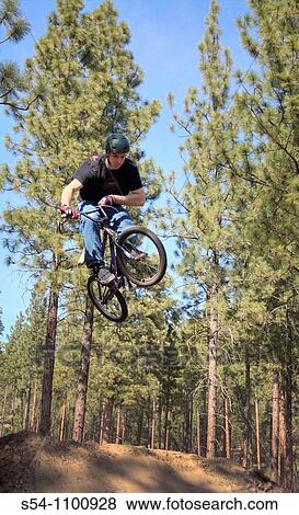 A rider on a bike jumping his bike at Camp Sekani Pak, Beacon Hill, Spokane, Washington, USA View Large Photo Image Stock Photo - A rider on a bike jumping his bike at Camp Sekani Pak, Beacon Hill, Spokane, Washington, USA. Fotosearch