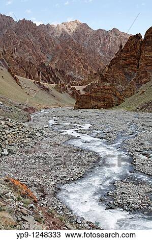 Stock Image - A river running through the jagged mountains of the Stok gorge in Ladakh, India. Fotosearch