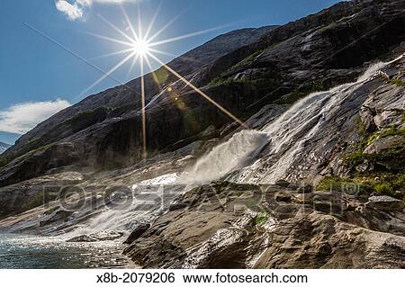 A roaring waterfall cascading down the mountain side deep in the fjord of Svartisen (Black Icea National Park), Nordfjord, Norway. View Large Photo Image Stock Photograph - A roaring waterfall cascading down the mountain side deep in the fjord of Svartisen (Black Icea National Park), Nordfjord, Norway.. Fotosearch