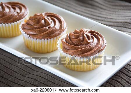 A row of chocolate cupcakes. View Large Photo Image Stock Photo - A row of chocolate cupcakes.. Fotosearch