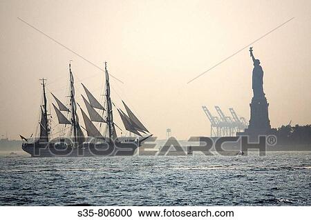 Stock Image - A sailing ship and Statue of Liberty in Upper New York Bay, New York City. USA. Fotosearch