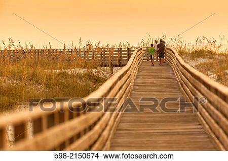 A scenic view of a boardwalk thru the sand dunes at the Gulf Coast State Park's white sand beach, in Orange Beach, Alabama View Large Photo Image Picture - A scenic view of a boardwalk thru the sand dunes at the Gulf Coast State Park's white sand beach, in Orange Beach, Alabama. Fotosearch