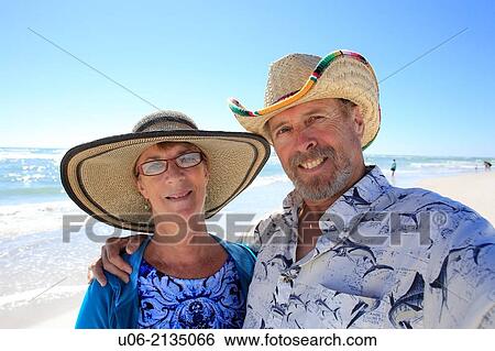 a senior couple smiling for the camera at a beach View Large Photo Image Stock Photograph - a senior couple smiling for the camera at a beach. Fotosearch