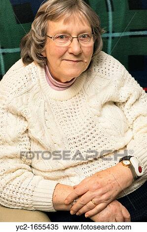 A senior elderly woman in her 70's with a home alarm unit on her wrist for emergencies at home in England, Britain, Uk View Large Photo Image Stock Photography - A senior elderly woman in her 70's with a home alarm unit on her wrist for emergencies at home in England, Britain, Uk. Fotosearch
