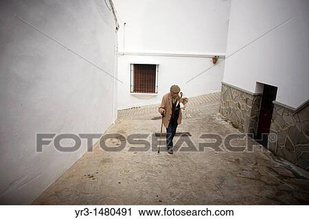 A senior man ups a hill using his walking stick in a street of El Gastor village in the Sierra de Grazalema Natural Park, Cadiz province, Andalusia, Spain, april 25, 2011 View Large Photo Image Stock Image - A senior man ups a hill using his walking stick in a street of El Gastor village in the Sierra de Grazalema Natural Park, Cadiz province, Andalusia, Spain, april 25, 2011. Fotosearch