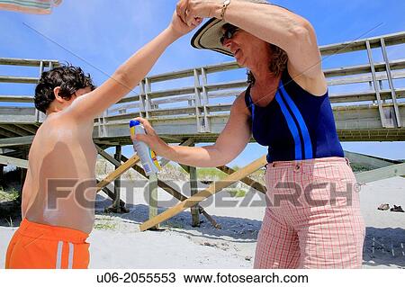 a senior woman applying sunscreen to her grandson at a beach View Large Photo Image Stock Image - a senior woman applying sunscreen to her grandson at a beach. Fotosearch