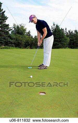 a senior woman golfing and putting on a golf course green View Large Photo Image Stock Image - a senior woman golfing and putting on a golf course green. Fotosearch