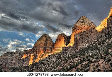A setting sun shines some light on the East Rim of Zion Canyon at Zion National Park, Utah View Large Photo Image Stock Photo - A setting sun shines some light on the East Rim of Zion Canyon at Zion National Park, Utah. Fotosearch
