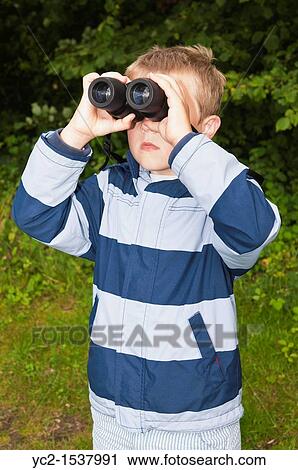 A seven year old boy birdwatching with binoculars at Fairhaven woodland and water garden in South Walsham, Norfolk, England, Britain, Uk View Large Photo Image Stock Image - A seven year old boy birdwatching with binoculars at Fairhaven woodland and water garden in South Walsham, Norfolk, England, Britain, Uk. Fotosearch