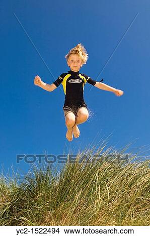 A seven year old boy playing in the sand dunes at Wells-next-the-sea, Norfolk, England, Britain, Uk View Large Photo Image Picture - A seven year old boy playing in the sand dunes at Wells-next-the-sea, Norfolk, England, Britain, Uk. Fotosearch