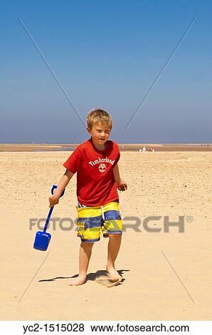 A seven year old boy playing on the beach at Wells-next-the-sea, Norfolk, England, Britain, Uk View Large Photo Image Stock Photo - A seven year old boy playing on the beach at Wells-next-the-sea, Norfolk, England, Britain, Uk. Fotosearch