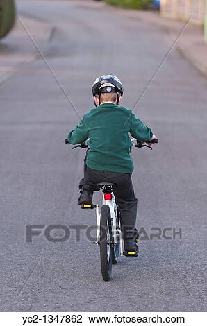 Stock Image - A seven year old boy riding his BMX bike in the Uk. Fotosearch
