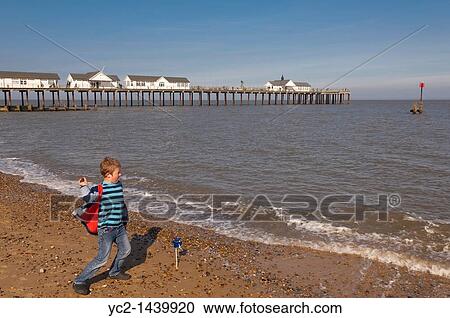 A seven year old boy throwing stones into the sea near the pier at Southwold, Suffolk, England, Britain, Uk View Large Photo Image Stock Image - A seven year old boy throwing stones into the sea near the pier at Southwold, Suffolk, England, Britain, Uk. Fotosearch