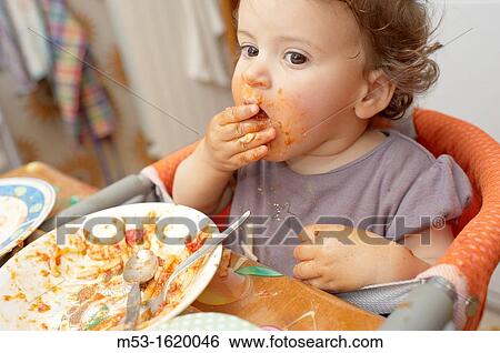 A seventeen months old baby girl eating tomato pasta using her hands View Large Photo Image Stock Photograph - A seventeen months old baby girl eating tomato pasta using her hands. Fotosearch