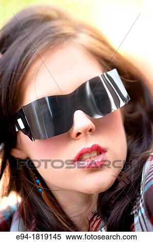A sexy portrait of a 19 year old brunette woman wearing large plastic sunglasses. View Large Photo Image Stock Photography - A sexy portrait of a 19 year old brunette woman wearing large plastic sunglasses.. Fotosearch