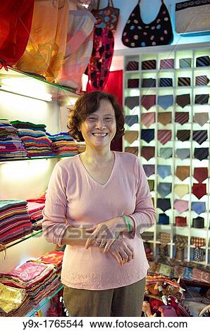 A shop owner shows off silk at the Nunal Boutique silk shop in Hanoi that sells colorful pieces of embroidered silk View Large Photo Image Picture - A shop owner shows off silk at the Nunal Boutique silk shop in Hanoi that sells colorful pieces of embroidered silk. Fotosearch