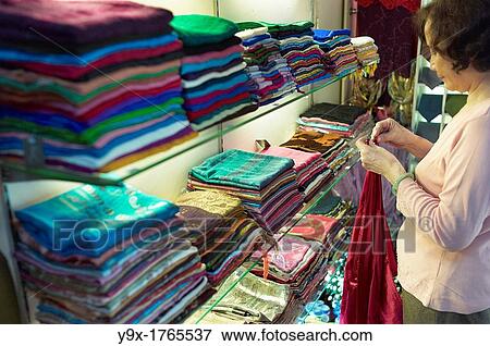 A shop owner shows off silk at the Nunal Boutique silk shop in Hanoi that sells colorful pieces of embroidered silk View Large Photo Image Stock Photo - A shop owner shows off silk at the Nunal Boutique silk shop in Hanoi that sells colorful pieces of embroidered silk. Fotosearch